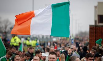 A Celtic fan flies an Irish Tricolour on the way to Ibrox on Beautiful Sunday